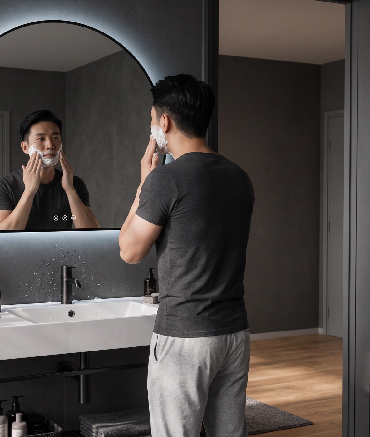A man shaving at a Matt Black HERA Luna LED mirror