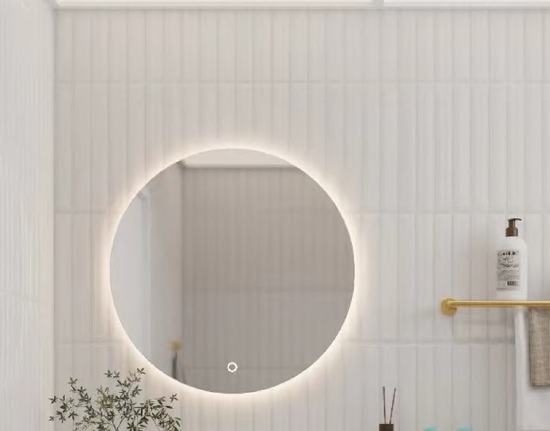 A Matt Gold towel rack beside a glowing round mirror